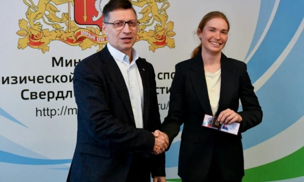 Леонид Рапопорт вручает удостоверение и значок "Мастер спорта международного класса" Тамаре Дербушевой